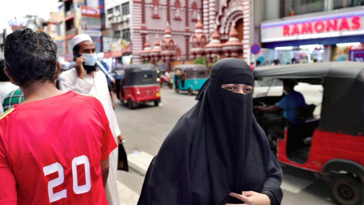 A burqa-clad Sri Lankan woman walks in a street of Colombo. — AP