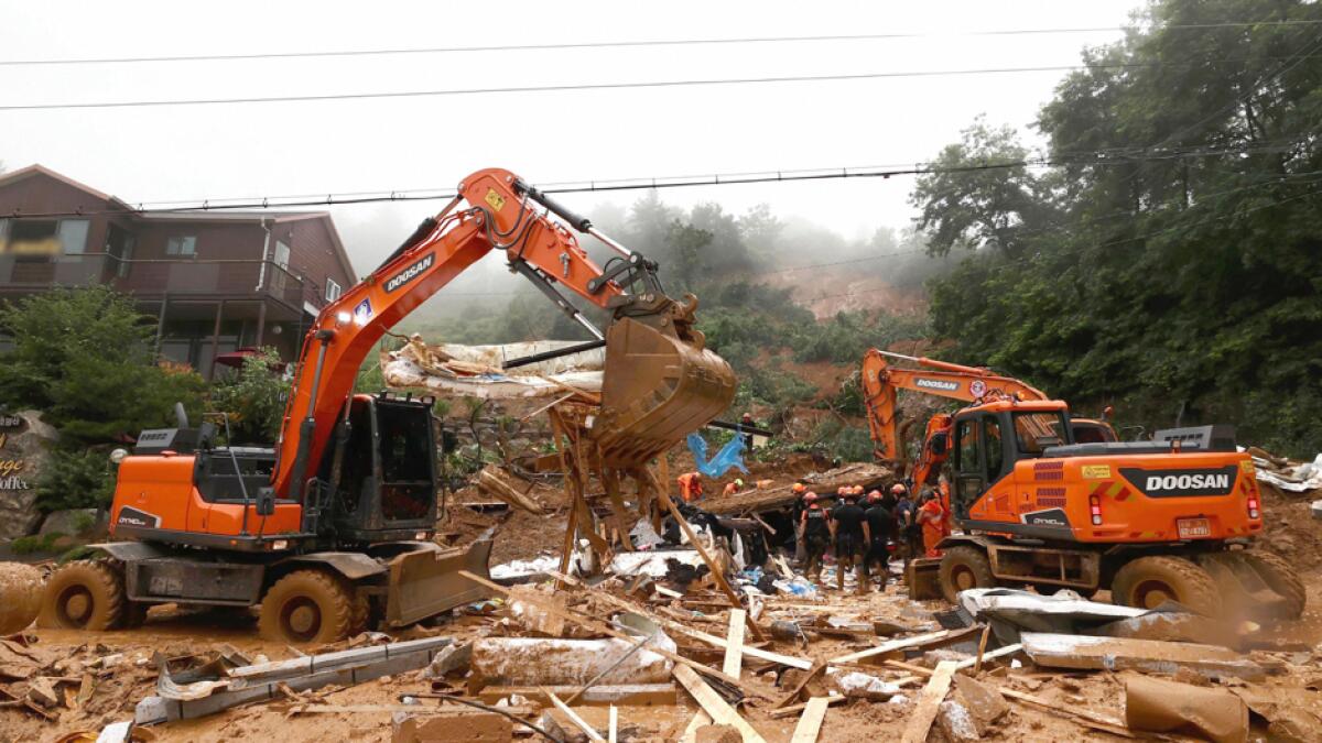 Rescue workers search for survivors at a damaged house after a landslide caused by heavy rain in Gapyeong, South Korea. South Korean Meteorological Administration issued a warning of heavy rain for Seoul and central area. Photo: AP