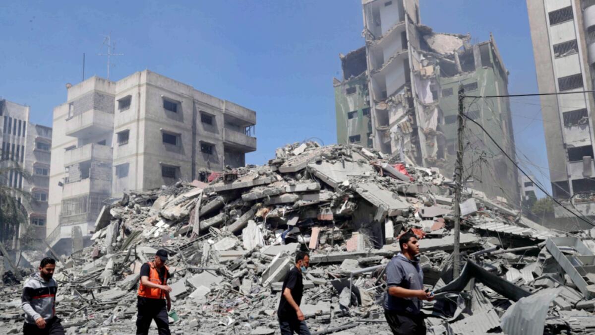 People inspect the the rubble of the Yazegi residential building that was destroyed by an Israeli airstrike in Gaza City. — AP