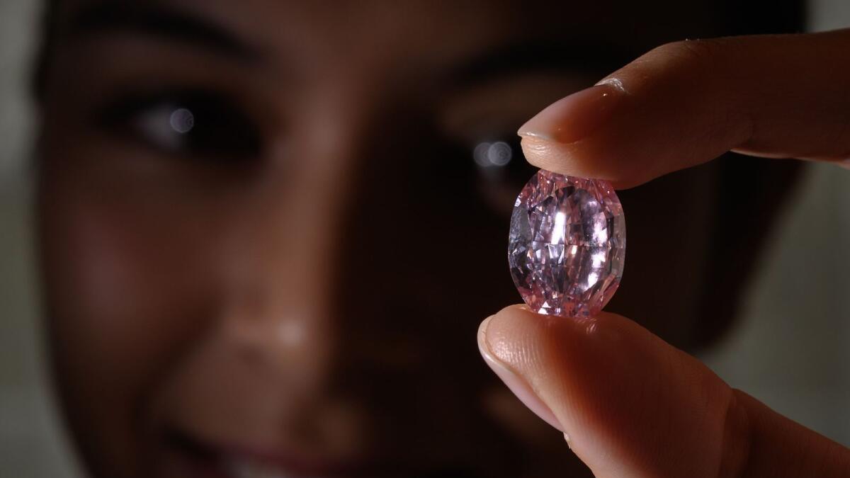 A model poses with the 'The Spirit of the Rose', a rare 14,83 carats vivid purple pink diamond, during a press preview ahead of sales by Sotheby's auction house in Geneva  on November 06, 2020.