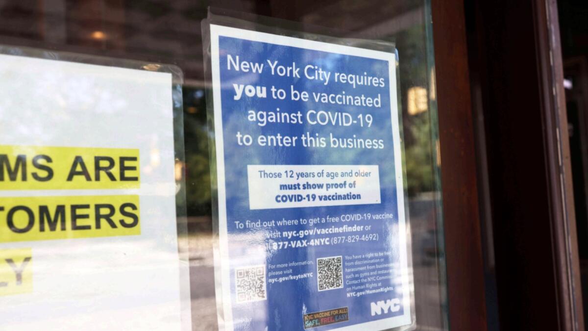 A Covid-19 vaccination sign is seen posted at the entrance of a cinema in New York. — AFP