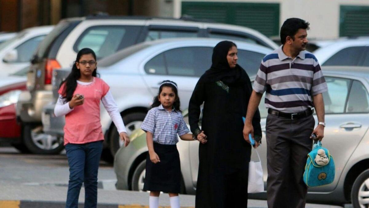 The children crossing the road with their parents.- Photo by M.Sajjad/ Khaleej Times
