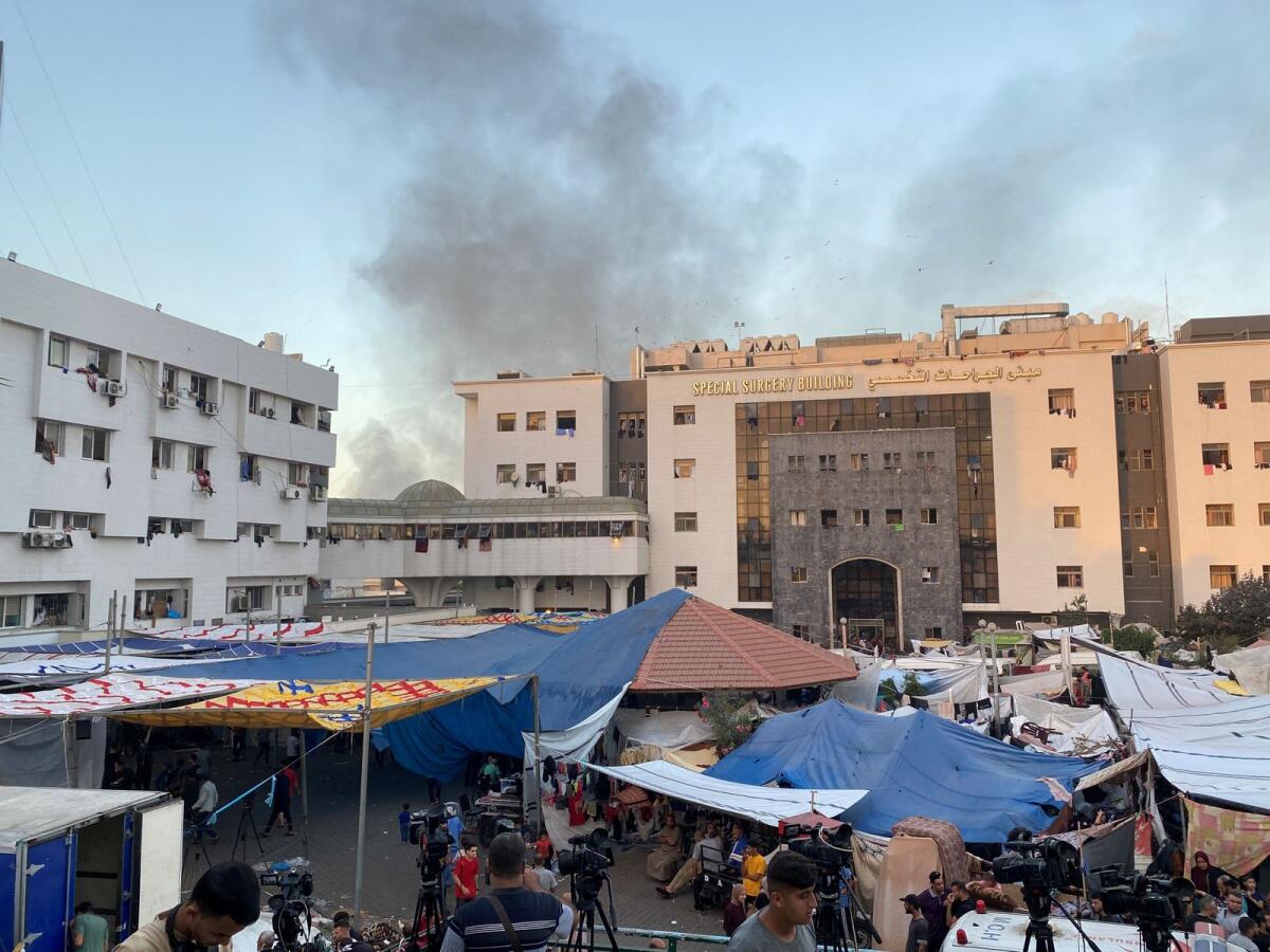 Smoke rises as displaced Palestinians take shelter at Al Shifa hospital. Photo: Reuters