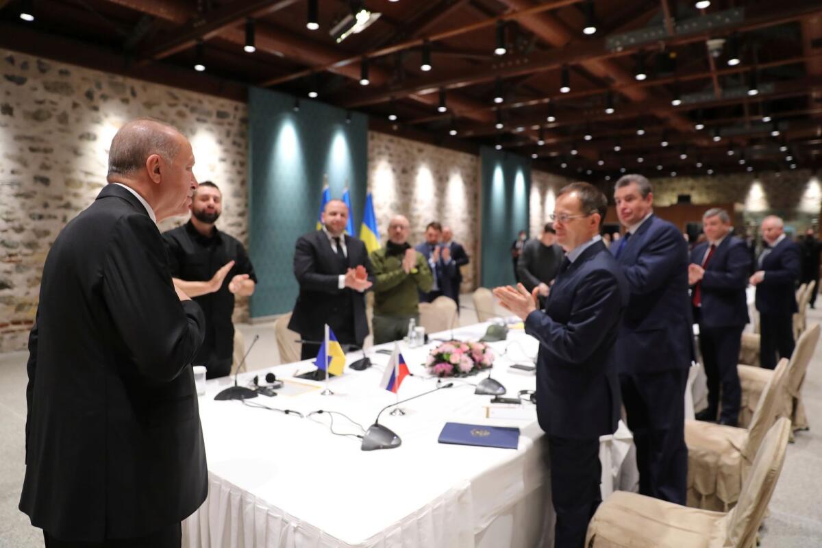 Turkish President Recep Tayyip Erdogan, left, welcomes the Russian, right, and Ukrainian delegations ahead of their talks in Istanbul, Turkey, Tuesday, March 29, 2022. The first face-to-face talks in two weeks between Russia and Ukraine were due to start Tuesday, raising flickering hopes of an end to a war that has ground into a bloody campaign of attrition. (Turkish Presidency via AP)