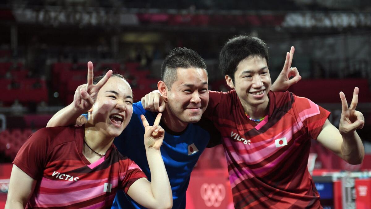 Japan's Jun Mizutani (rght) and Mima Ito (left) celebrate after beating China's Xu Xin and Liu Shiwen in their mixed doubles table tennis final match. (AFP)