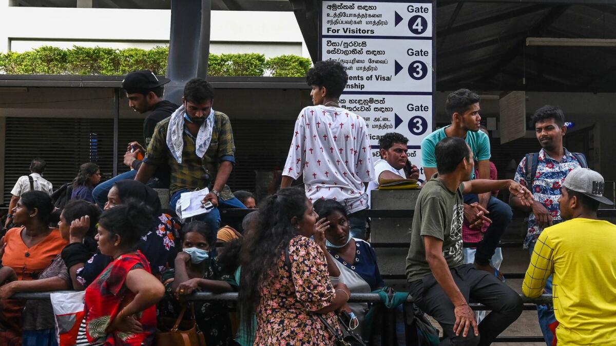 People gather in front of the department of Immigration and Emigration to apply for a passport in Colombo on 18 July 2022. (Photo by AFP)