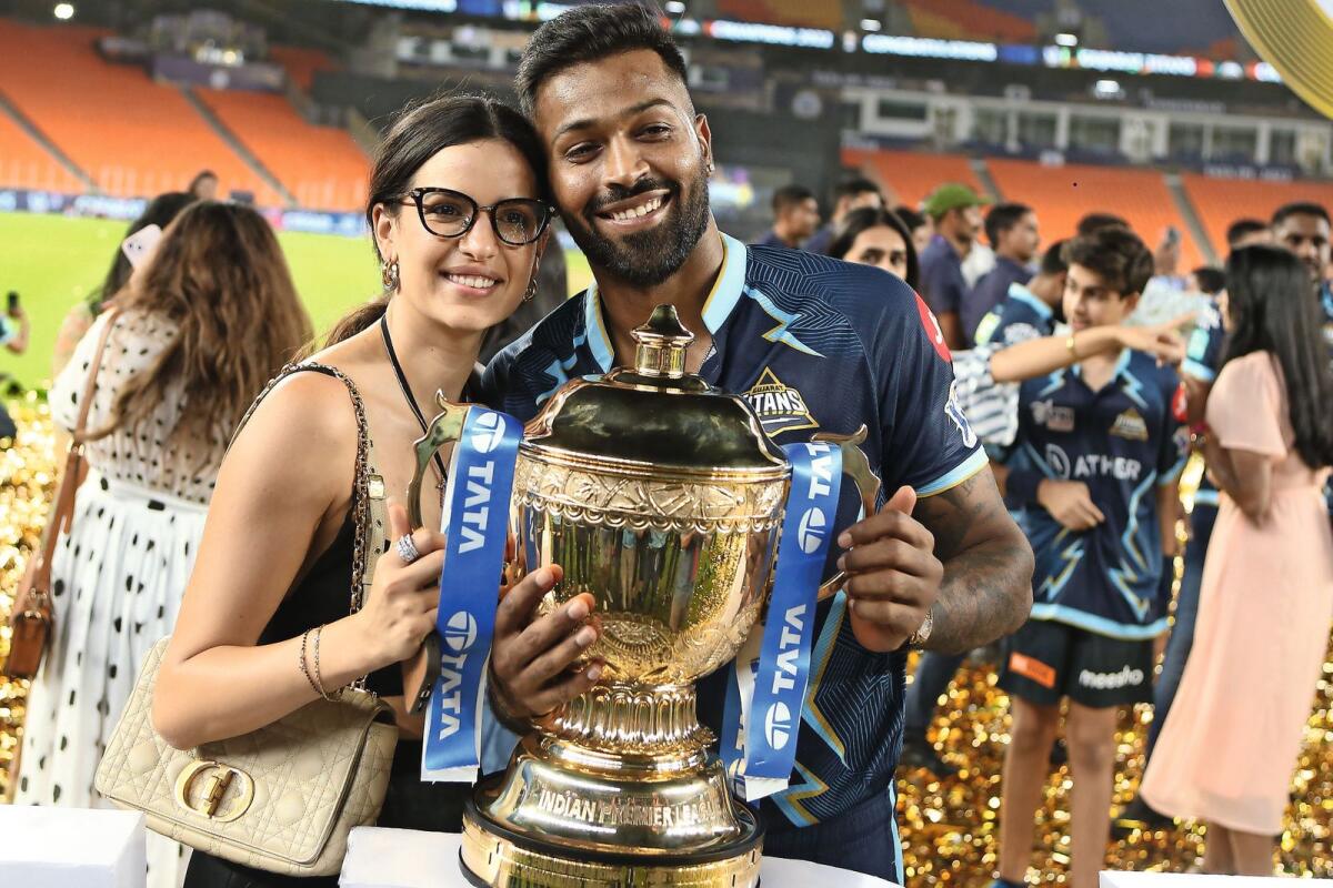 Gujarat Titans captain Hardik Pandya (right) with his wife and the IPL trophy. — BCCI