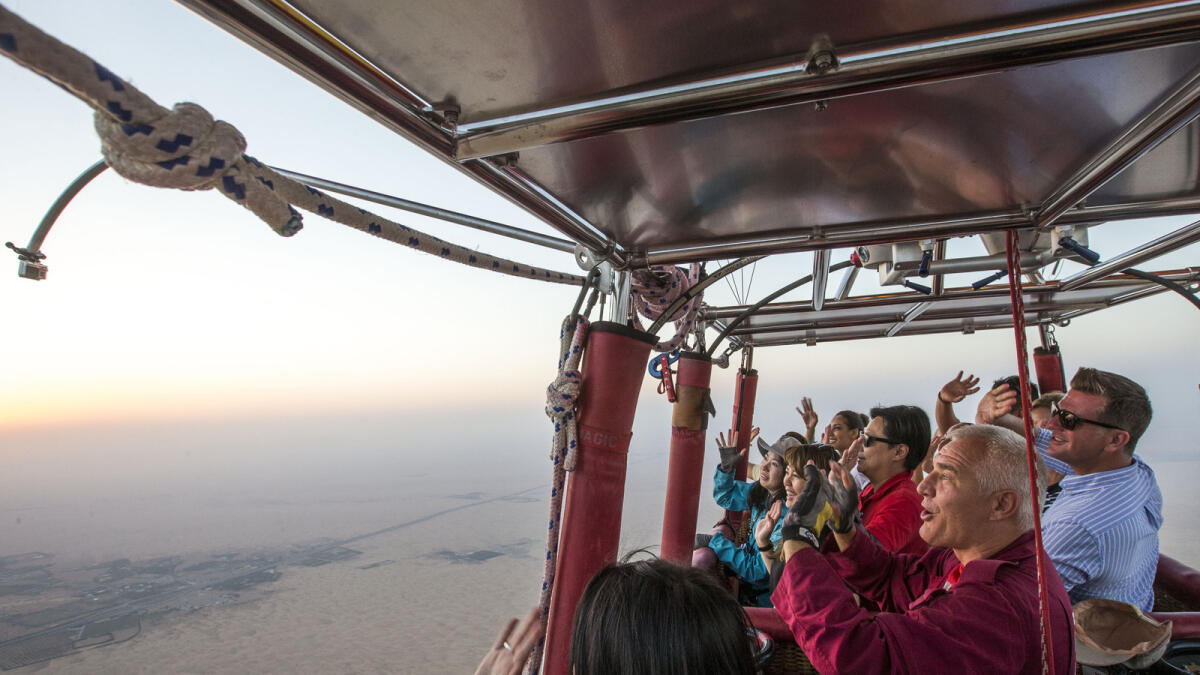 Passengers wave at the camera with Capt. Peter at Balloon Adventures, Dubai on Monday.