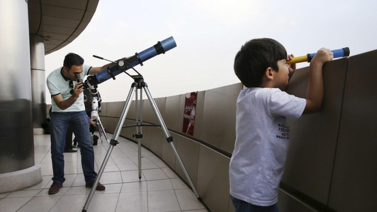 Iranian astrologist Ehsan Mehrjou, left, searches the sky with a telescope for the new moon that signals the start of the Muslims' holy month of Ramadan.