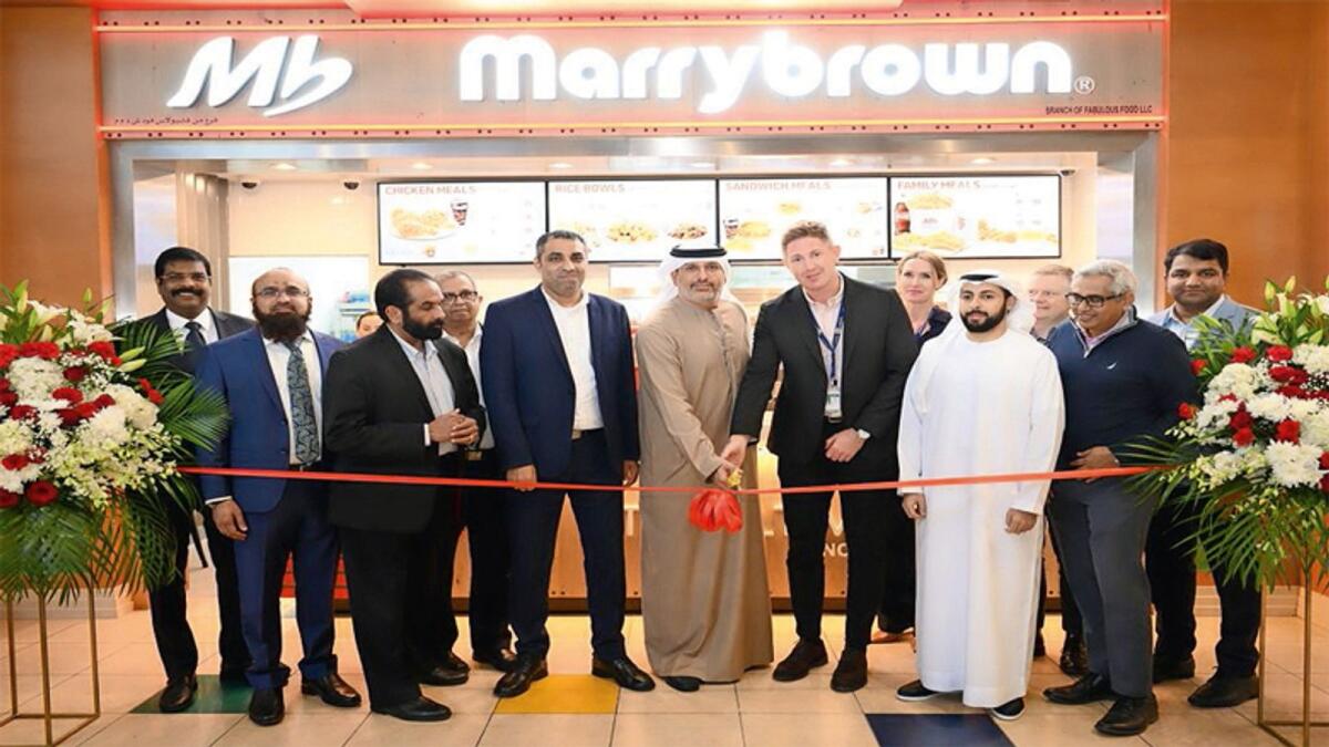 Hadi Al Abbas and John Roger inaugurating the outlet in the Viewers Gallery food court, Dubai Airport Terminal 1 in the presence of Abdulla Al Abbas and Al Abbas Group Members.