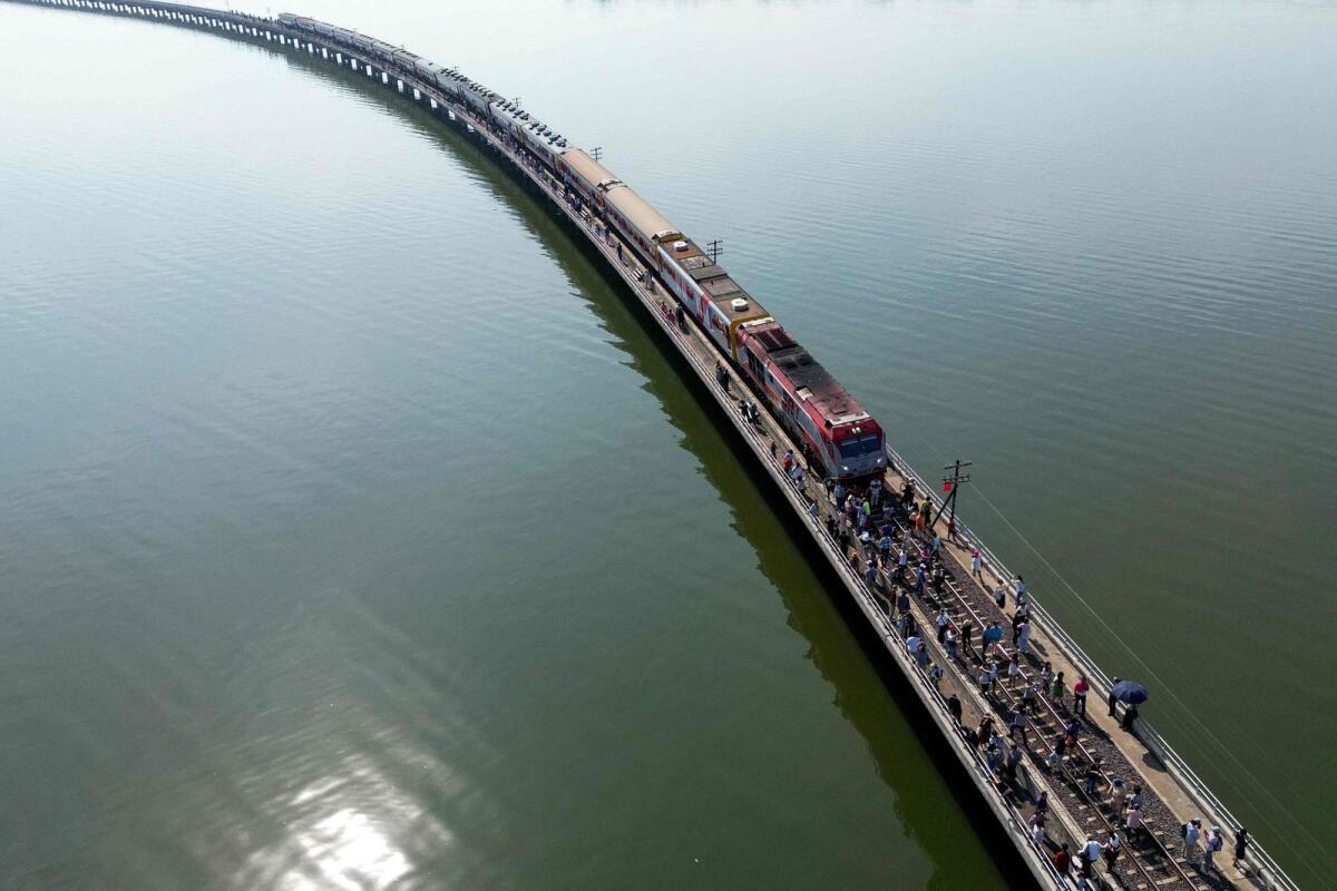 This aerial photograph taken on November 4, 2023 shows tourists travelling aboard the popular 'Floating train' taking photographs along the railway tracks during a stop in the middle of Pasak Jolasid Dam, Thailand’s biggest reservoir in Lopburi province.  — AFP