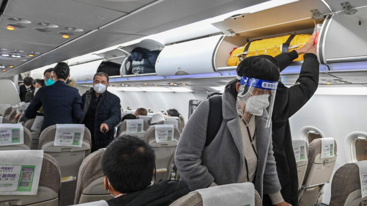 A passenger wearing a face shield and mask amid the Covid-19 pandemic boards a domestic flight at Shanghai Pudong International Airport in Shanghai on January 3. _ AFP