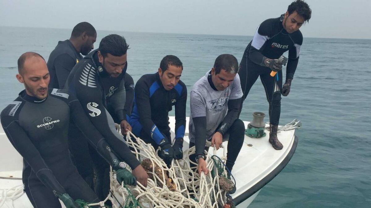 A team of divers pull up a fishing net from the wreckage of MV Dara. 