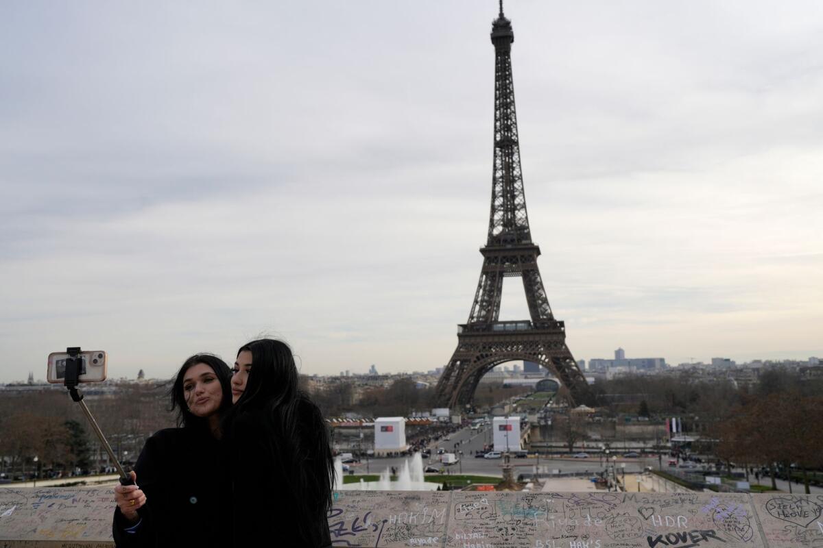 Tourists make a selfie in front of the Eiffel Tower on Wednesday in Paris.