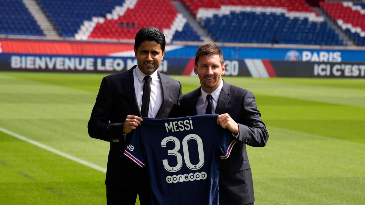 Lionel Messi and PSG president Nasser Al-Al-Khelaifi hold Messi's jersey. (AP)