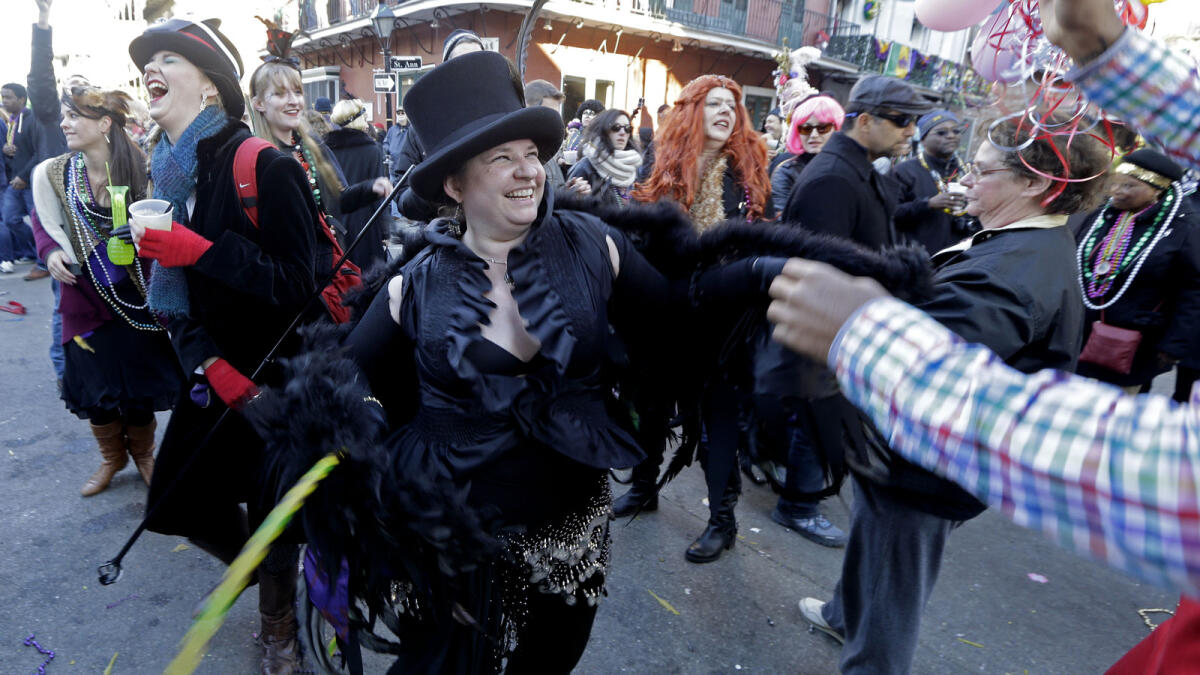 Revellers dance in the street during Mardi Gras day festivities.