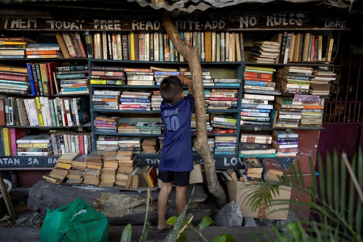 A boy picks out a book at Hernando Guanlao's communal library in Makati, Metro Manila, Philippines, on February 7, 2024. — Reuters