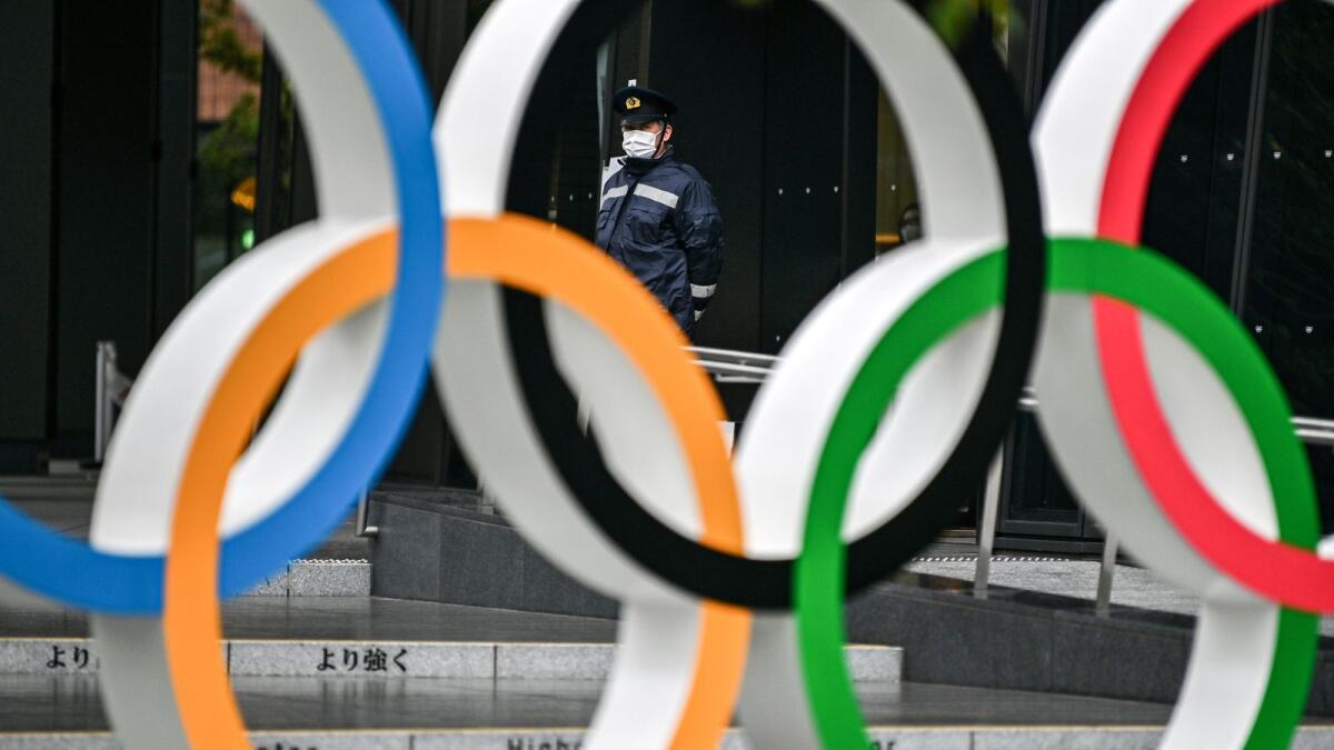 A security guard stands behind the Olympic rings at the Japan Olympic Museum in Tokyo on Thursday. (AFP)