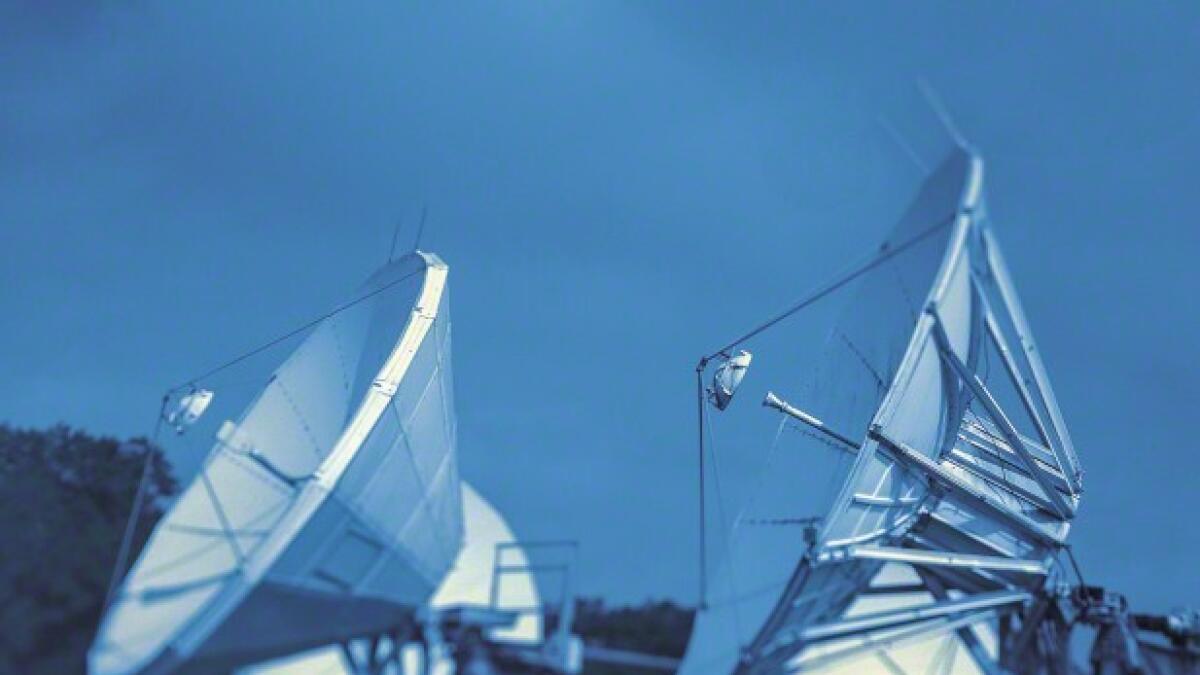 Satellite dish receivers against cloudy sky