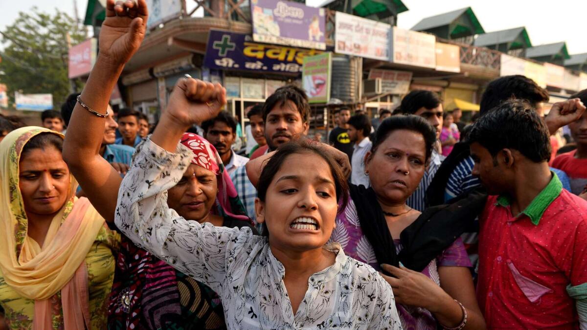 Protesters shout slogans during a demonstration near the home of a minor girl who was raped in New Delhi on Saturday. — AFP