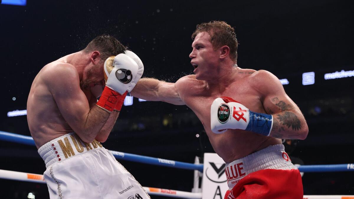 Canelo Alvarez (red trunks) and Callum Smith (white trunks) during their WBA, WBC and Ring Magazine super middleweight championship bout. — Reuters