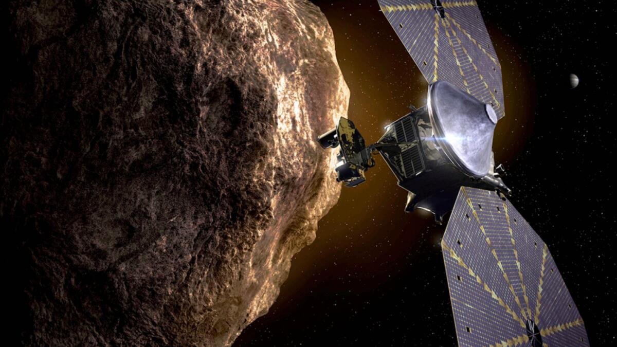 The image depicts the Lucy spacecraft approaching an asteroid. — AP