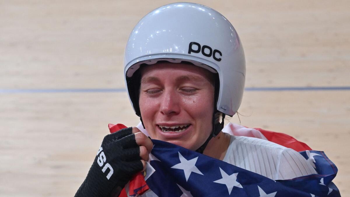 Gold medallist USA's Jennifer Valente reacts as she poses with a flag after the women's track cycling omnium points race. — AFP