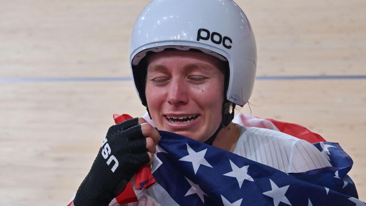Gold medallist USA's Jennifer Valente reacts as she poses with a flag after the women's track cycling omnium points race. — AFP
