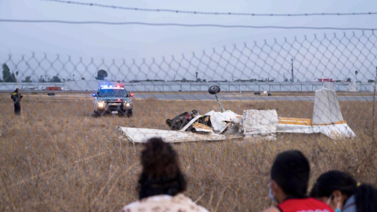 People look at the wreckage from a plane crash at Watsonville Municipal Airport in California. — AP