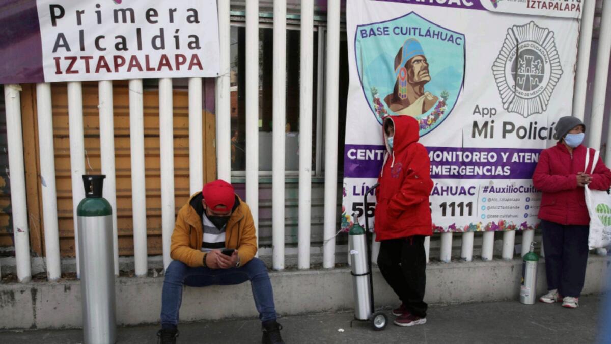 People wait their turn to fill their tanks with oxygen, in the Iztapalapa borough of Mexico City. — AP