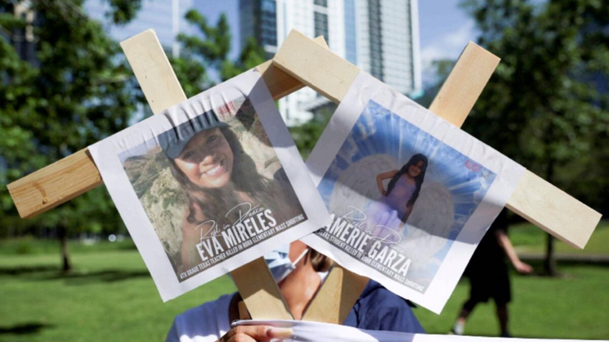 A person holds pictures of victims of the Texas shooting as they protest against gun laws outside the National Rifle Association (NRA) annual convention in Houston. — Reuters