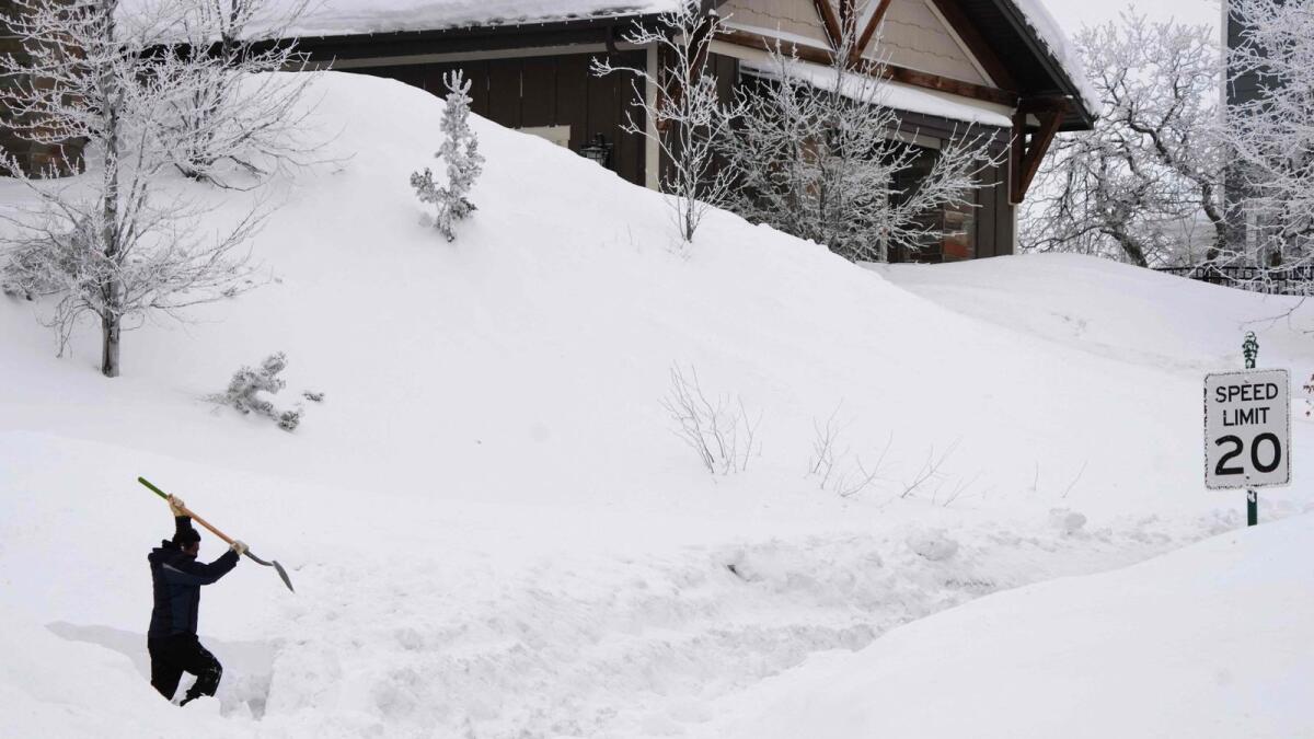 A person tries to shovel a path from their house to the street in Draper, Utah, on February 23, 2023. — AFP