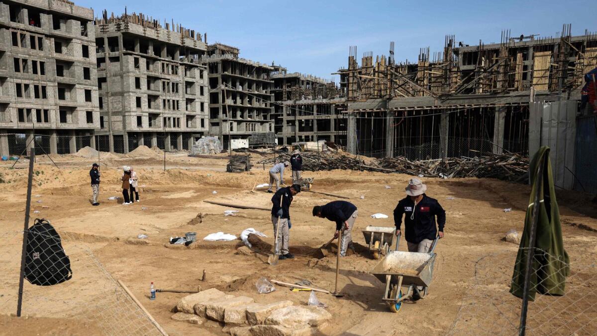 Palestinian workers excavate a recently-discovered Roman cemetery containing ornately decorated graves in Beit Lahia in the northern Gaza Strip on Monday. — AFP