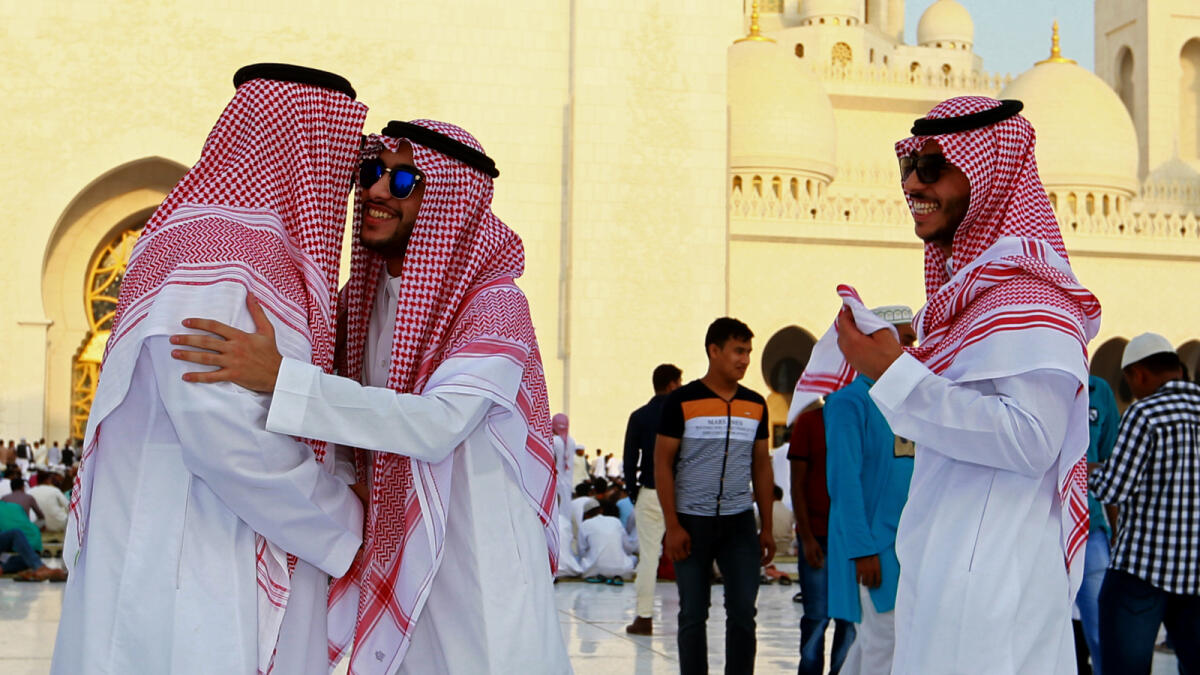 ALL THE WAY FROM SAUDI ... Visitors from Saudi Arabia greet each other after Eid prayers at the Shaikh Zayed Grand Mosque. - Photo By Nezar Balout/ Khaleej Times
