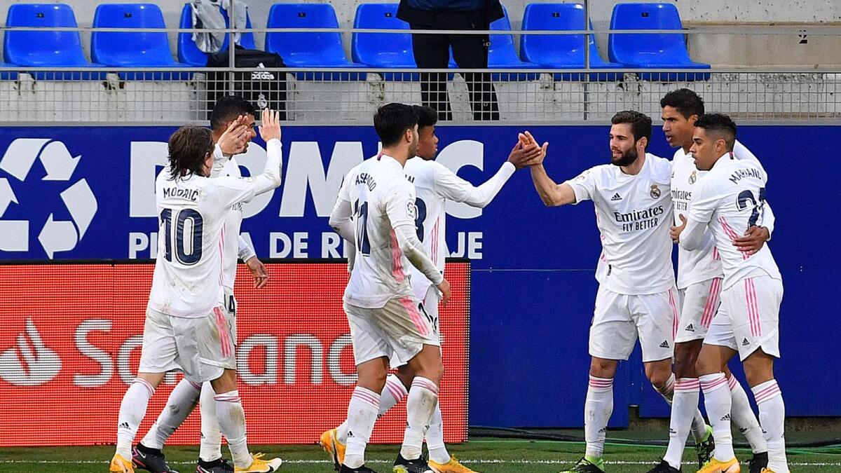 Real Madrid's French defender Raphael Varane (second right) celebrates with teammates after scoring a goal against Huesca during the Spanish league match. — AFP
