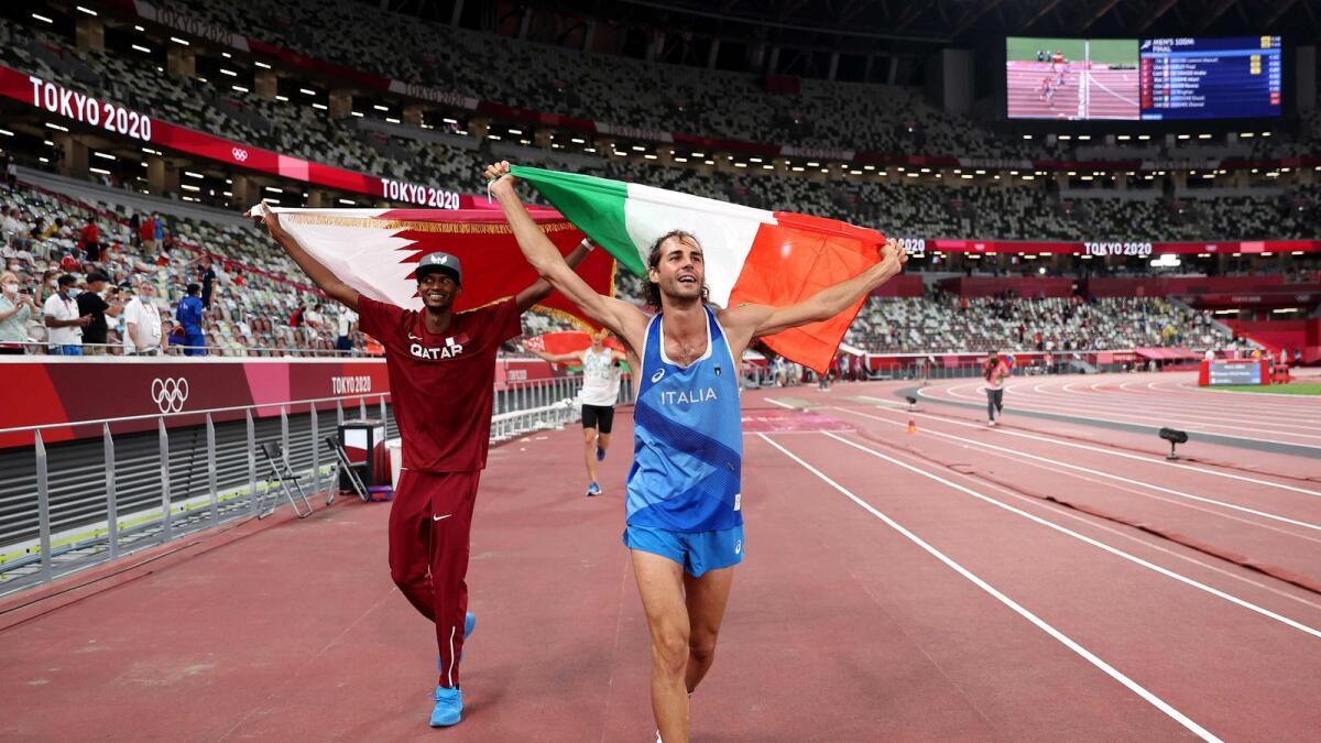 Mutaz Essa Barshim (left) of Team Qatar and Gianmarco Tamberi of Team Italy celebrate on the track following the Men's High Jump Final. — AFP