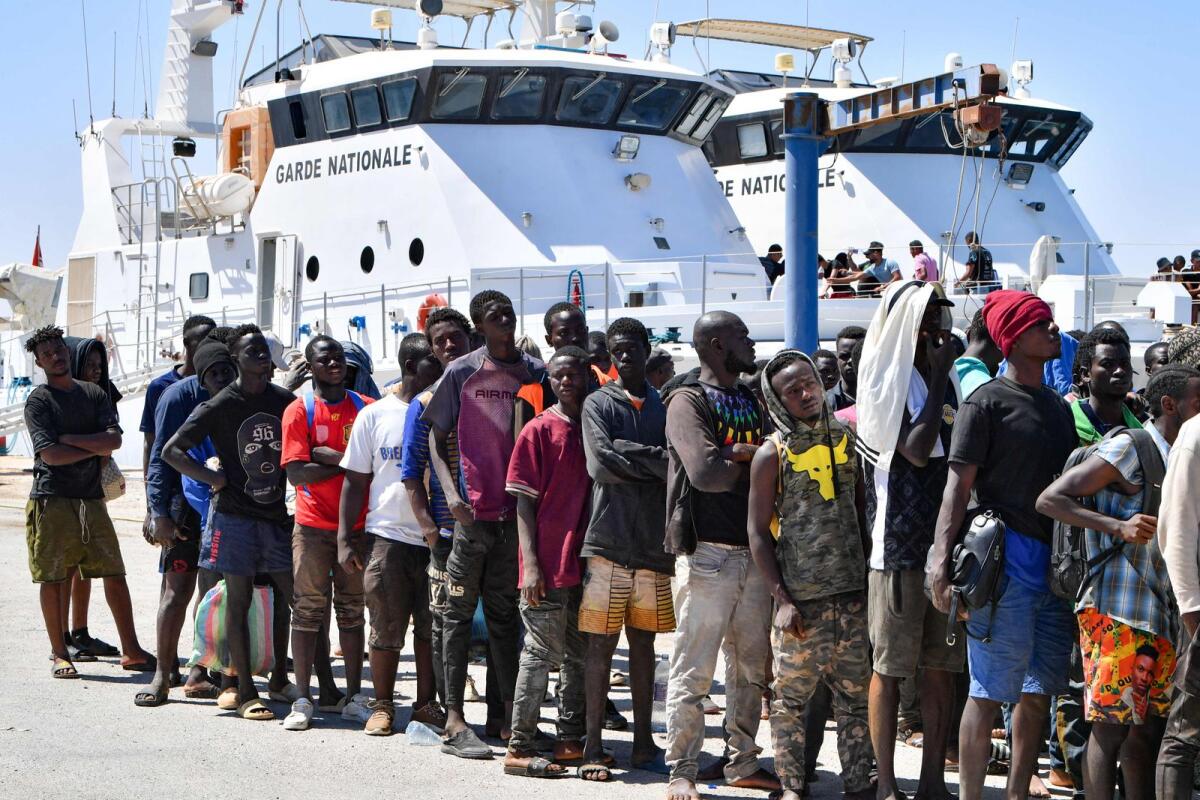 Migrants of African origin trying to flee to Europe disembark in Sfax from a ship owned by the Tunisian coast guards, after being intercepted by them at sea on August 10, 2023.  — AFP