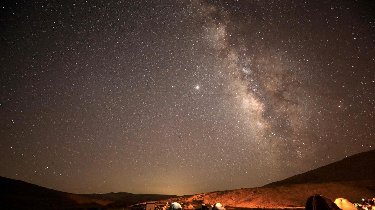 A Perseid meteor streaks across the sky above a camping site at the Negev desert near the city of Mitzpe Ramon during the Perseids meteor shower, which occurs every year when the Earth passes through the cloud of debris left by the comet Swift-Tuttle. Photo: AFP