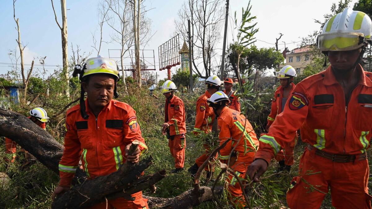 Members of a rescue team clean up fallen trees in Sittwe. — AFP