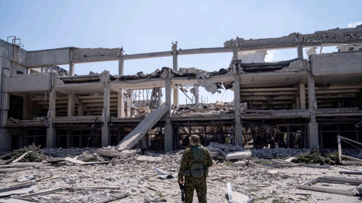 Ukrainian serviceman looks on National Pedagogic university destroyed by a Russian attack in Kharkiv. — AP