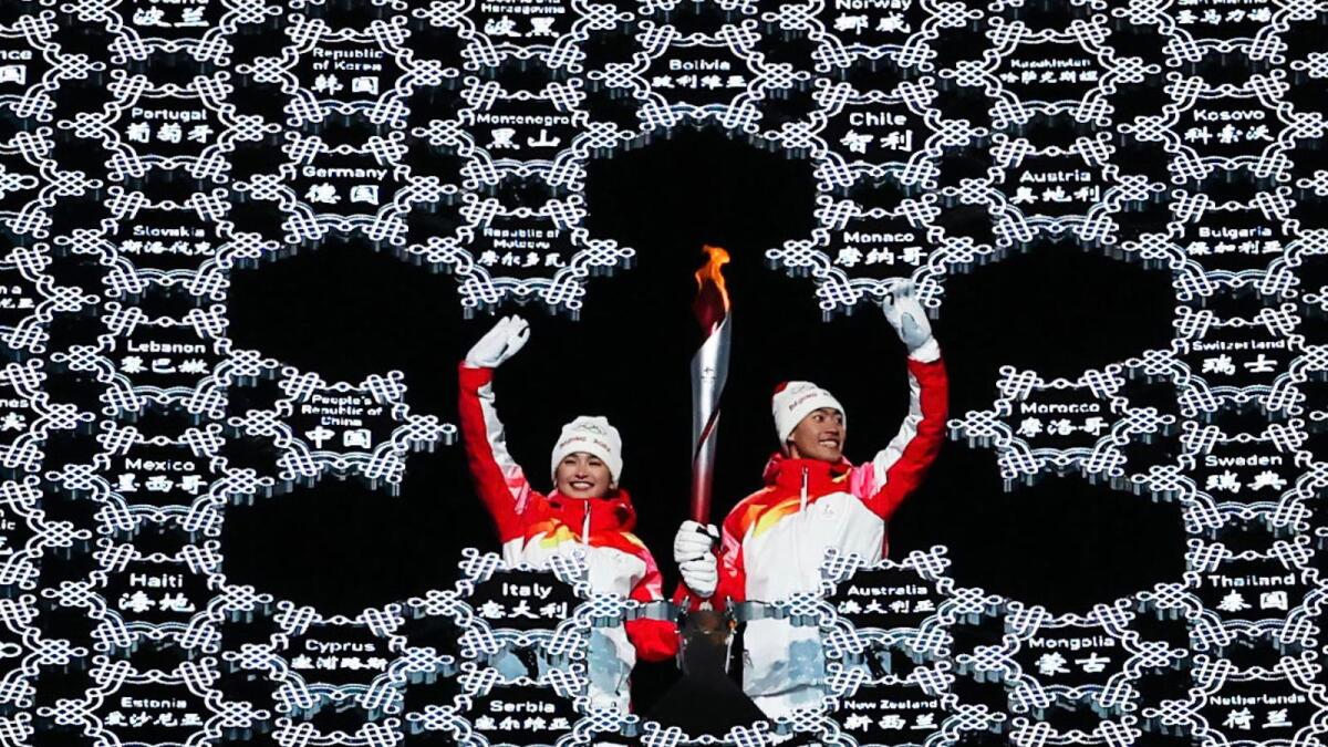 Chinese athletes Dinigeer Yilamujiang (left) and Zhao Jiawen place the Olympic flame inside a giant snowflake during the opening ceremony of the 2022 Winter Olympics. The snowflake was used in lieu of the traditional cauldron as the 24th Winter Games got off to a unique start. XINHUA