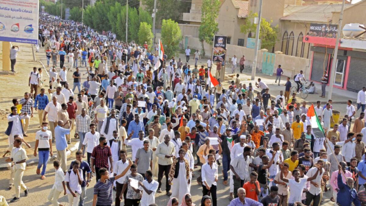 Sudanese protesters lift national flags during a demonstration calling for a return to civilian rule in the Red Sea city of Port Sudan. — AFP