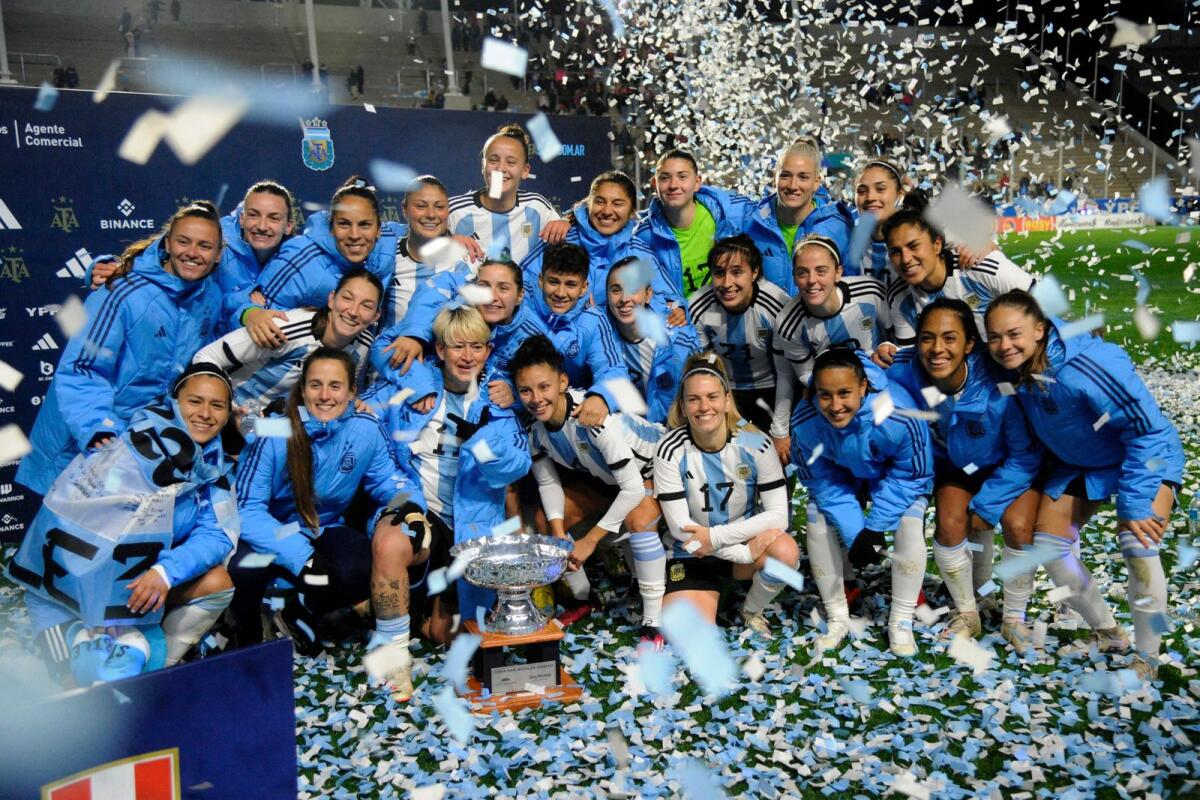 Argentina players celebrate with the trophy at the end of the friendly football against Peru, ahead of the Fifa Women's World Cup. — AFP