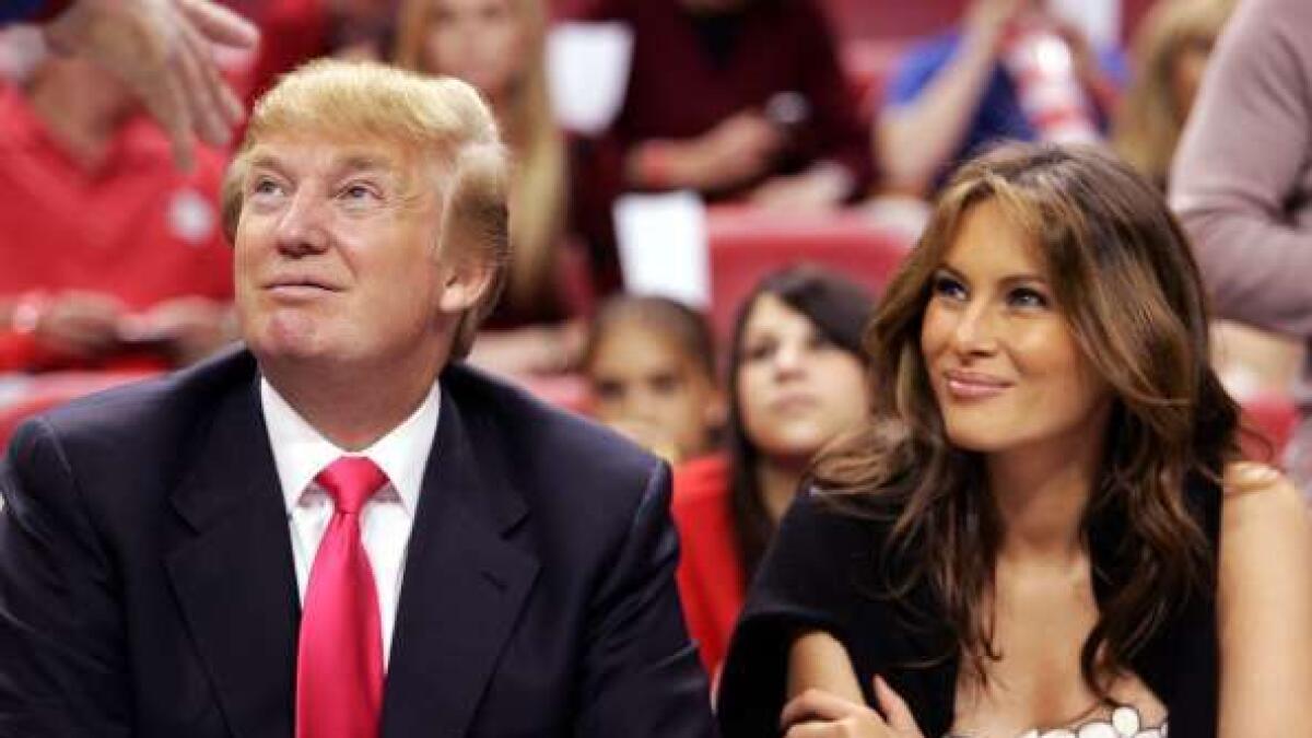 Donald Trump and his wife Melania watch the Miami Heat play the Los Angeles Lakers on Christmas Day in Miami, December 25, 2005.