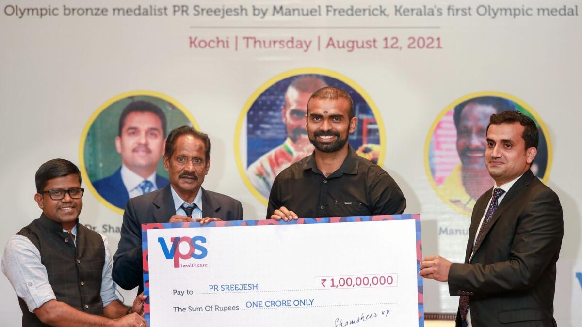 Kerala’s first Olympic medal winner Manuel Frederick presents PR Sreejesh with Rs10 million cheque. — Supplied photo