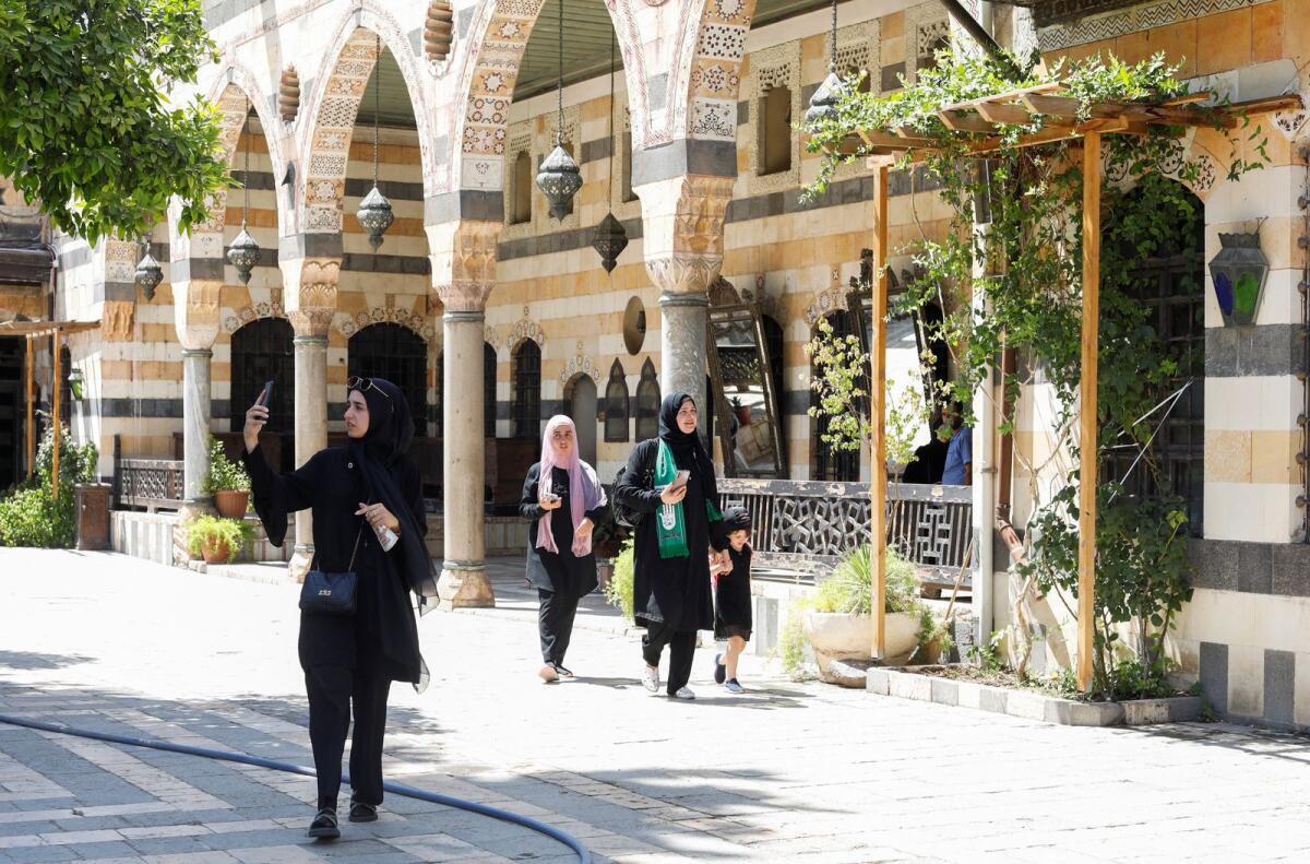 A visitor uses a mobile phone as she walks at Al Azem Palace in Damascus, Syria July 31, 2022. Photo: Reuters