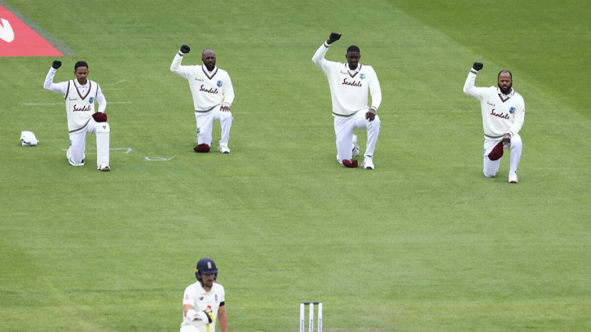 West Indies players and England's Rory Burns, foreground, take a knee before the start of the first day of the second cricket Test match between England and West Indies at Old Trafford in Manchester, England. Photo: AP