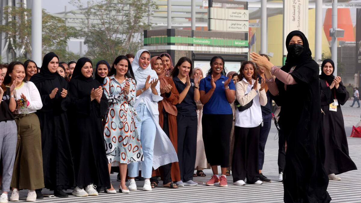 A group photo of Reem Ebrahim Al Hashimy (R2), UAE Minister of State for International Cooperation and Director General of Expo 2020 Dubai and Expo staff during International Women's Day (IWD) outside Terra - The Sustainability Pavilion, Expo 2020.
