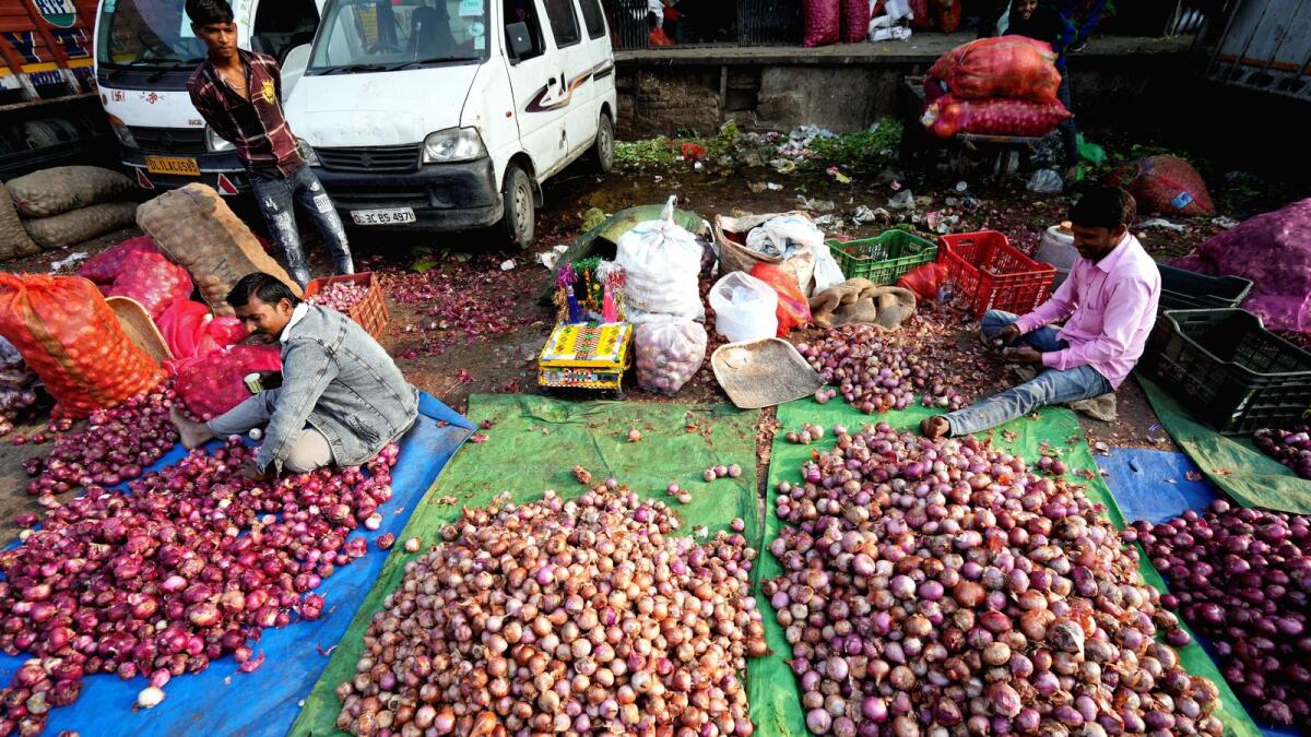 Workers sort onions at Azadpur Mandi as the retail price of onion remains elevated in New Delh on November 18, 2023. — PTI