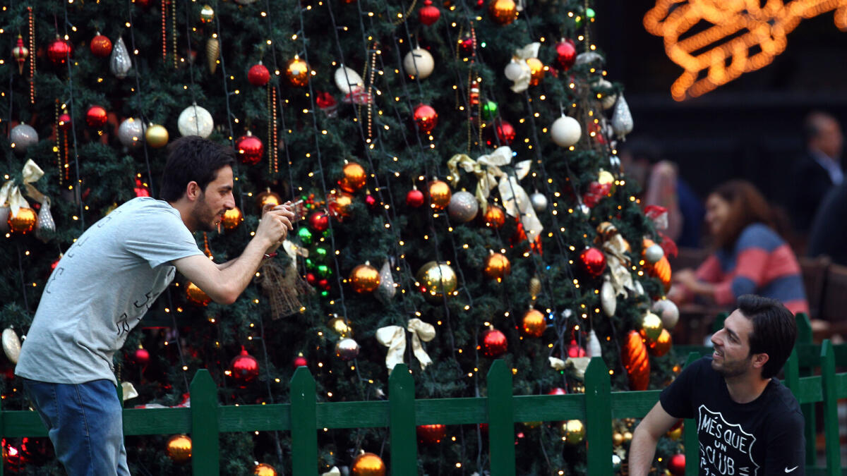 Friend takes pictures in front of Xmas tree in Irish village at Garhoud Dubai. KT photo by Shihab